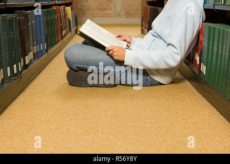 Female student reading in the library Stock Photo