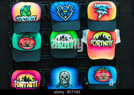 Colourful airbrushed caps with a Fortnite design.  Fortnite is a popular video game. Stock Photo