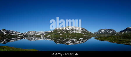 Snowy mountains reflecting perfectly in the Votna Lake on the Haukelifjell, Norway. Stock Photo