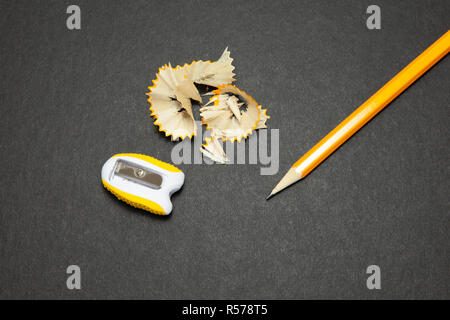 Sharpened pencil and sharpener on black background. Stock Photo