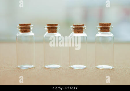 Empty little bottles with cork stopper, on blurred background Stock Photo