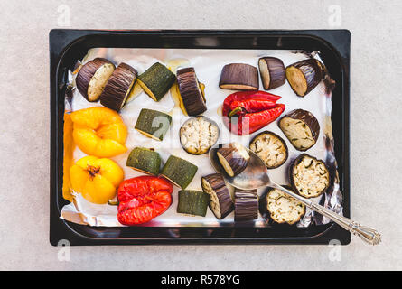 Vegetables on a baking tray. Baked pieces of red and yellow peppers, zucchini, and eggplants. Stock Photo