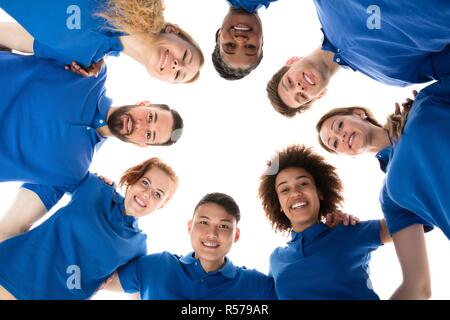 Happy Multiracial Janitors Forming Huddle Stock Photo