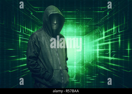 Hooded with anonymous mask standing with binary code Stock Photo
