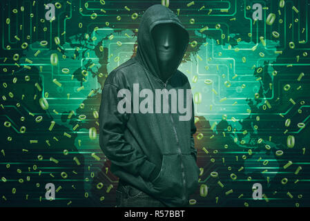 Hooded hacker with anonymous mask standing Stock Photo