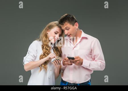 Business concept. The two young colleagues holding mobile phones on gray background Stock Photo