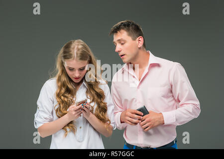 Business concept. The two young colleagues holding mobile phones on gray background Stock Photo