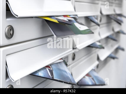 Modern mailboxes filled of flyers. Business and advertising concepts. Shallow depth of field. Stock Photo