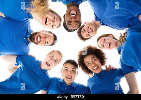 Group Of Smiling Janitors Forming Huddle Stock Photo