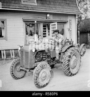 Finland History -  A Finnish Farmer works with a tractor at the Yllänen Osuusliikkeen Rannanmäki store. ca. 1955 Stock Photo