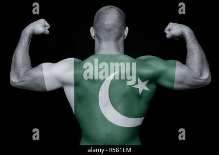 The back of a young athletic man wearing a T-shirt with the national flag of Pakistan on a black isolated background. The concept of national pride an Stock Photo