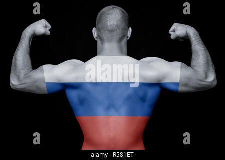 The back of a young athletic man wearing a T-shirt with the national flag of Russia on a black isolated background. The concept of national pride and 
