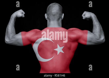 The back of a young sporty man wearing a T-shirt with the national flag of Turkey on a black isolated background. The concept of national pride and pa Stock Photo