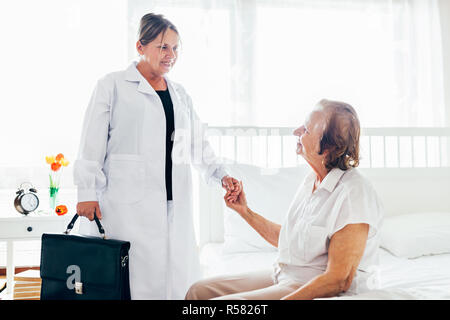 Providing care for elderly. Doctor visiting elderly patient at home. Stock Photo