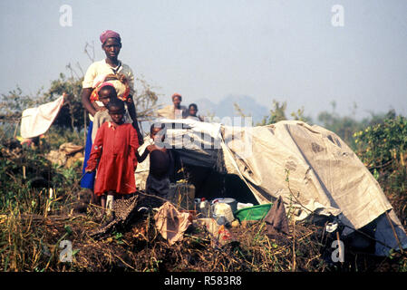 1994 - A Rwandan family pose in front of their makeshift home.  The refugees entered Goma Zaire after a civil war erupted in their country. Operation Support Hope Stock Photo