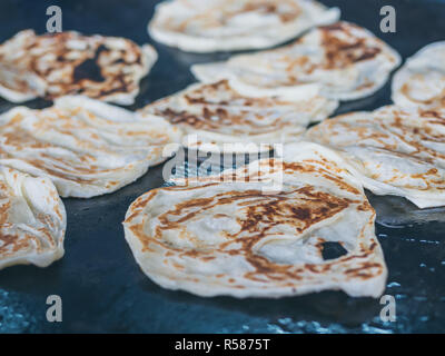 Roti Making, roti thresh flour by roti maker with oil. Indian traditional street food. Roti is fried on the pan. Stock Photo