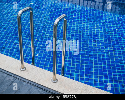 Grab bars ladder in swimming pool. Swimming pool stairs with copy space. Stock Photo
