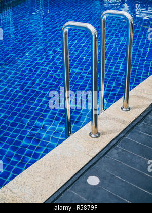 Grab bars ladder in swimming pool vertical style. Swimming pool stairs. Stock Photo