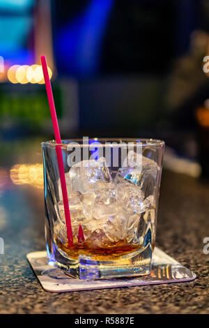 Empty Mixed Drink Cocktail Glass with Straw on Bar Coaster on Bar Top Room for Copy Stock Photo