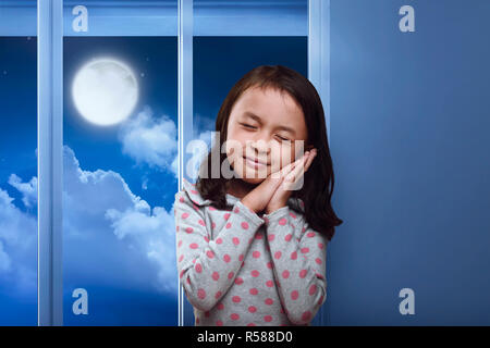 Funny asian kid sleeping on her hand in the home Stock Photo