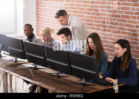 Student With Teacher In Computer School Classroom Stock Photo