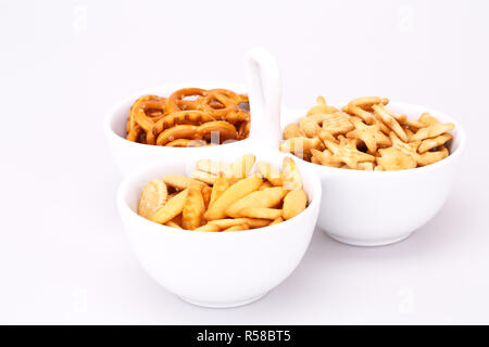 Different salted crackers in bowl isolated on white background. Stock Photo