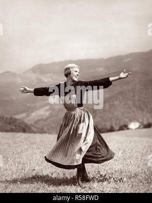 Julie Andrews twirling and singing on a mountaintop meadow in the 1965 Academy Award winning movie, The Sound of Music. Stock Photo