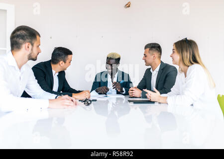 Meeting of business partners using laptops and talking at the table Stock Photo