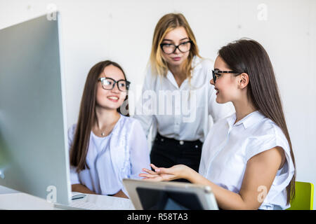 Diverse young and senior female colleagues excited by online win or business achievement, multiracial happy businesswomen celebrating victory looking  Stock Photo