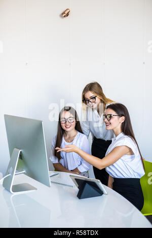 Diverse young and senior female colleagues excited by online win or business achievement, multiracial happy businesswomen celebrating victory looking  Stock Photo