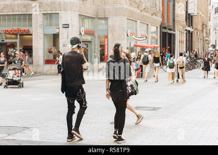 Germany, Leipzig, September 6, 2018: Young couple punks or friends walking down the street in Leipzig. He listens to music on the phone. Youth subculture. Stock Photo