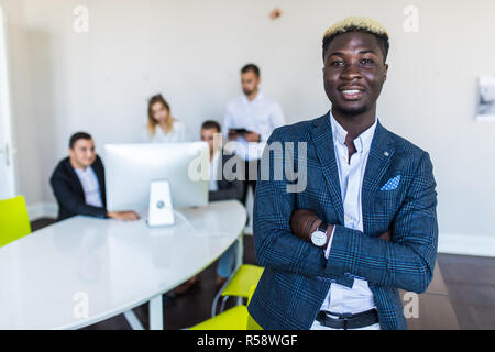 Young African-American Business leader standing inf front of business team smiling Stock Photo