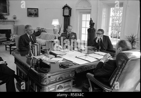 This photograph was taken in the Oval Office of the White House. Pictured with President Ford are Brent Scowcroft, Deputy Assistant to the President for National Security Affairs; Graham Martin, United States Ambassador to the Republic of Vietnam; Army Chief of Staff General Frederick Weyand; and Secretary of State Henry A. Kissinger.  Gerald Ford has his back to the camera. Brent Scowcroft is partially obscured. Stock Photo