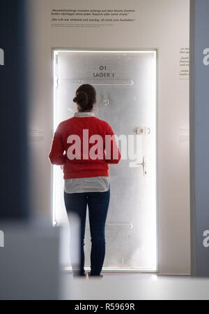30 November 2018, Baden-Wuerttemberg, Stuttgart: A young woman stands during a press appointment in the permanent exhibition of the memorial place 'Hotel Silber' in front of a former cell door. After an almost demolition, long planning and several postponements, the former headquarters of the Secret State Police (Gestapo) is opened on 04 December as a 'place of historical-political learning'. Photo: Marijan Murat/dpa Stock Photo
