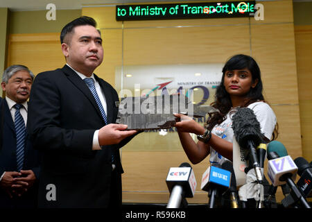 Putrajaya, Malaysia. 30th November, 2018. APossible debris of the missing MH370 was handed over to Malaysian Transport Minister Anthony Loke Siew Fook (L) in Putrajaya, Malaysia, Nov. 30, 2018. Loke said Friday the government was open to resuming the search for Malaysia Airlines Flight MH370 but that requires 'new credible evidence.' MH370, carrying 239 on board, went missing en route from Kuala Lumpur to Beijing on March 8, 2014. Its main wreckage is yet to be found. (Xinhua/Chong Voon Chung) Credit: Xinhua/Alamy Live News Stock Photo