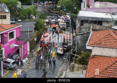 Sao Paulo, Brazil. November 30, 2018 - Firefighters work at a place where a small plane crashed on Friday afternoon, near Camp de Marte, in the north of Sao Paulo. The aircraft, a Cessna 210, crashed over two homes shortly after it took off. At least two people were killed and 12 others injured. Credit: Dario Oliveira/ZUMA Wire/Alamy Live News Stock Photo