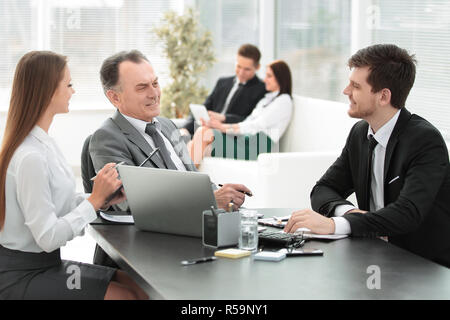 client talking with the staff at the Desk in the office Stock Photo