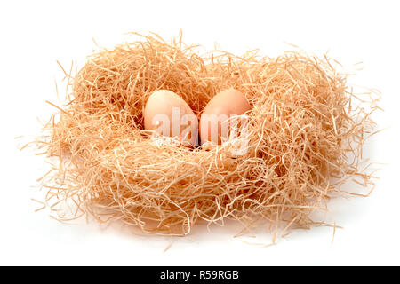 Eggs in a straw nest on a white background Stock Photo