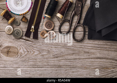 Tools for repair and tailoring clothes on wooden table with copy space, top view Stock Photo