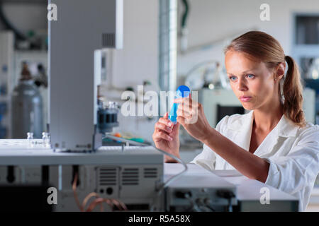 Portrait of a female researcher doing research in a lab, using a tablet computer for data collection and visualization(shallow DOF  color toned image) Stock Photo