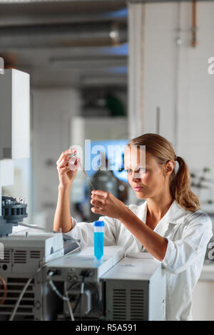 Portrait of a female researcher doing research in a lab, using a tablet computer for data collection and visualization(shallow DOF  color toned image) Stock Photo
