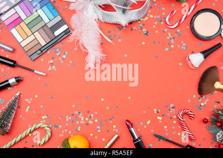 Photo on top of eye shadows, brushes, feather mask, tangerine, sugar cane, confetti Stock Photo