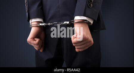 Close now arrested men hand with dark background and handcuffs Stock Photo