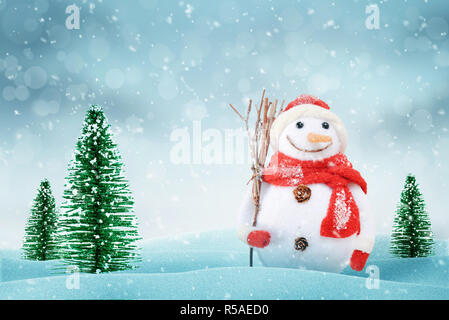 Snowman on New Year winter scene. Christmas trees and snow beside. Stock Photo