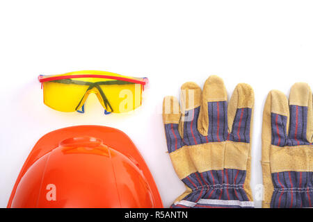 Orange hard hat, leather work gloves and safety glasses on a white background Stock Photo