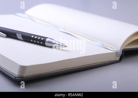 black stylish notebook and ballpoint pen on the office desk Stock Photo