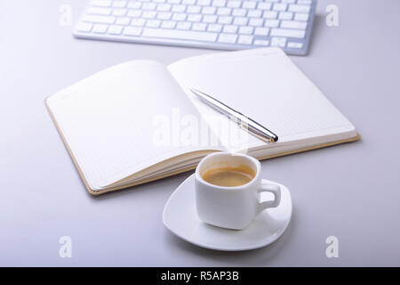 office table with notebook, ballpoint pen, computer keyboard, cup of coffee, tablet pc. copy space Stock Photo
