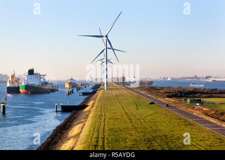 Ships moored in the canal Caland near turbines in the port of Rotterdam Stock Photo