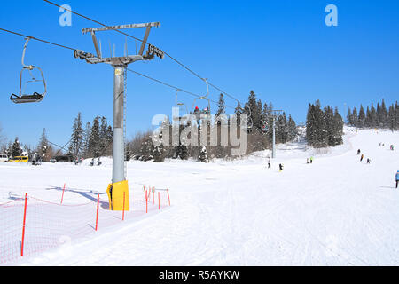 Skiers on lift in mountains. A close up Stock Photo