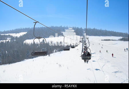 Skiers on lift in mountains. A close up Stock Photo